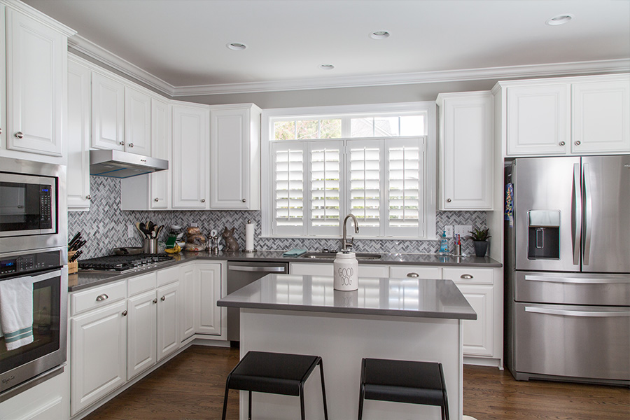 White Polywood shutters on a window over a kitchen sink