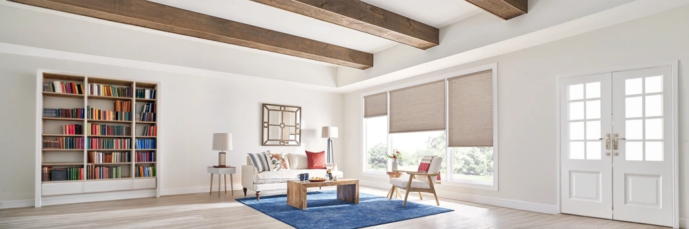 Beige motorized cellular shades on large living room windows