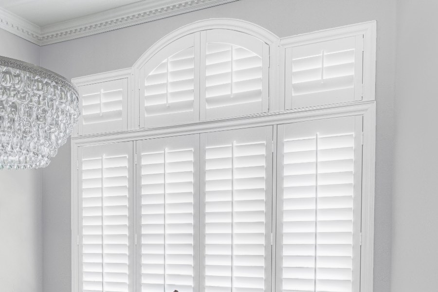 Trying to install DIY plantation shutters on large or speciality sized windows like these can be a challenge. Instead, turn to professionals and get the job done right. Plantation shutters covering windows in dining room.