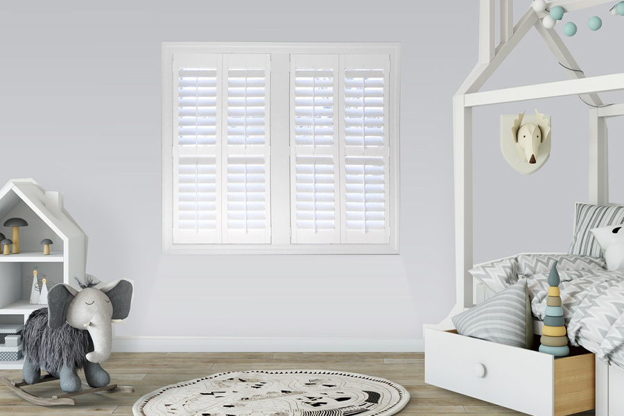 White Polywood shutters make your nursery beautiful and cozy. White Polywood shutters in a large nursery bedroom.